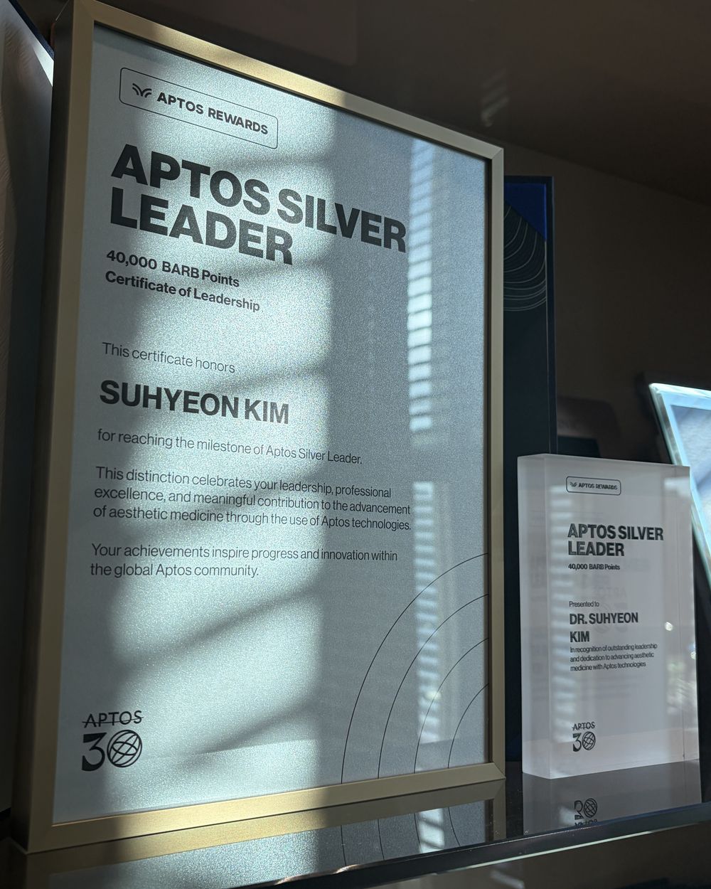 APTOS Silver Leader 인증패 — 김수현 원장 이름이 적힌 액자와 크리스털 트로피